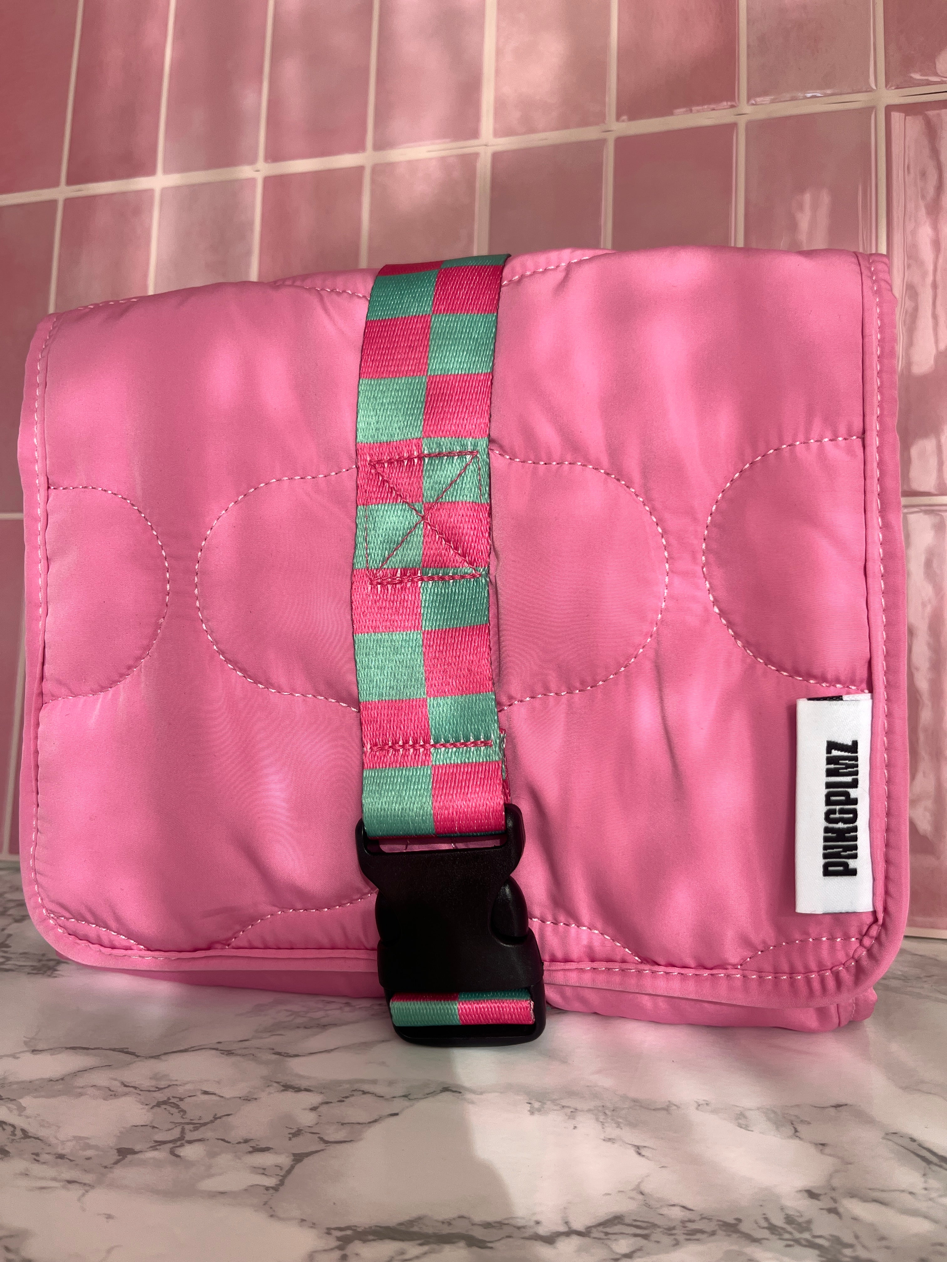 Roze quilted travel sleeve – zonlicht en schaduw op marmeren oppervlak