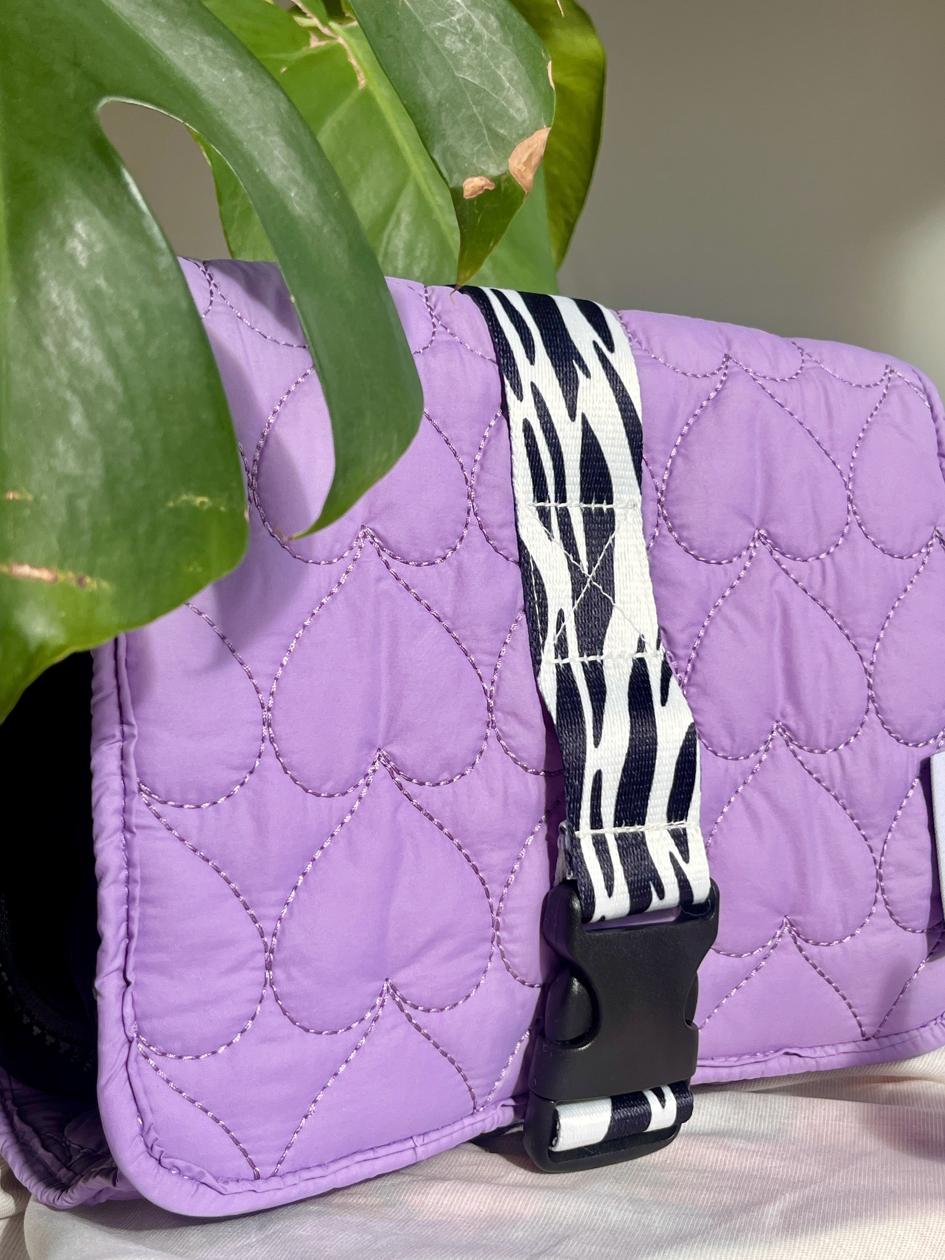 Paarse travel set op zachte achtergrond – sfeerbeeld met make-up accessoires